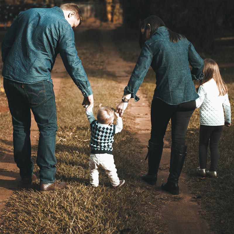 Family walking away holding hands.